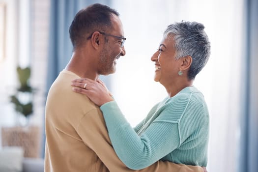 Happy, love and romance with a senior couple laughing, hugging or dancing together in their home. Dance, romantic and smile with a happy mature man and woman enjoying their retirement while bonding.