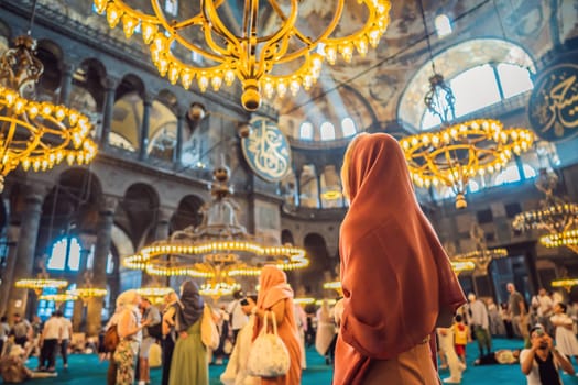 INSCRIPTION - denoting the names of Allah, the Prophet Muhammad, as well as the first 4 caliphs Woman tourist enjoying Hagia Sofia, Ayasofya interior in Istanbul, Turkey, Byzantine architecture, city landmark and architectural world wonder. Turkiye.