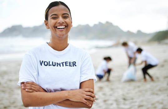 Smile, portrait and volunteer woman at beach for cleaning, recycling and sustainability. Earth day, laughing and proud female with arms crossed for community service, charity and climate change