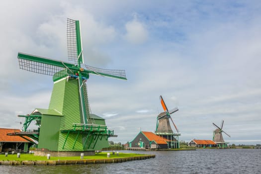 Netherlands. Summer day at the Zaanse Schans. Vintage windmills on the river bank