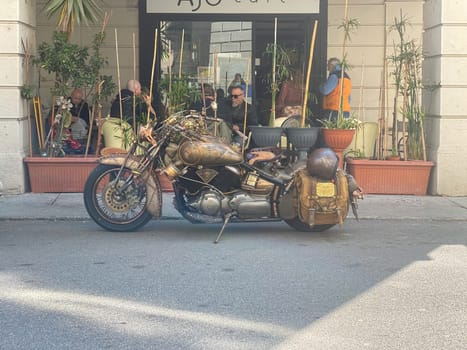 Cremona, Italy - April 2023 steampunk motor cycle parked in the street near a bar