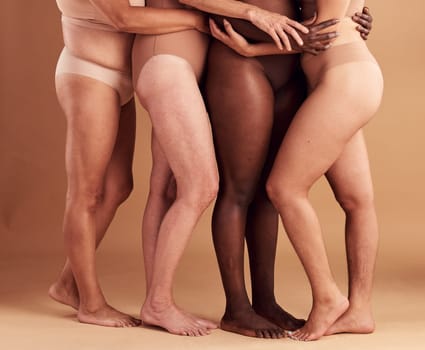 Diversity, legs and body positivity, women in underwear huddle together on studio background. Feet, friends and health, empowerment in self love and care in global community of diverse female bodies