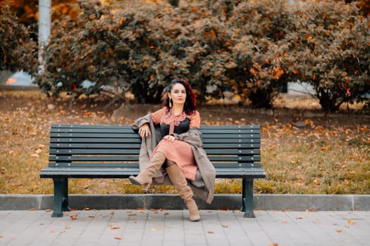 A woman walks outdoors in autumn, enjoys the autumn weather