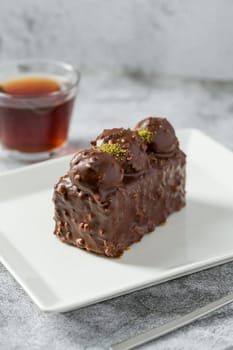 Cake with profiteroles with tea on stone table