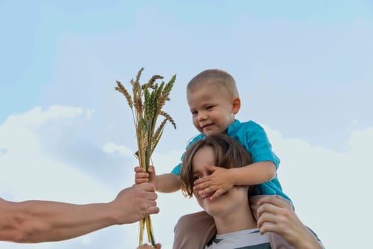 A family with a dad, a teenager and a small child are walking carefree and fun in a field with wheat. It's time to harvest. The food crisis in the world. A field for harvesting bread.