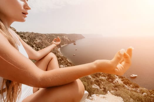 Middle aged well looking woman with black hair doing Pilates with the ring on the yoga mat near the sea on the pebble beach. Female fitness yoga concept. Healthy lifestyle, harmony and meditation.