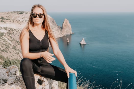 Fitness woman sea. Outdoor workout on yoga mat in park near to ocean beach. Female fitness pilates yoga routine concept. Healthy lifestyle. Happy fit woman exercising with rubber band in park.