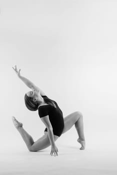 Young beautiful dancer posing on studio background with copy space