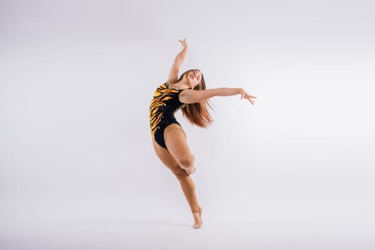 Young beautiful dancer posing on studio background with copy space