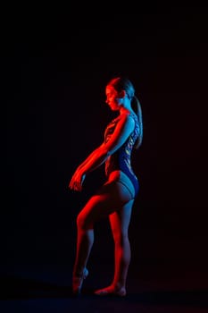 Young beautiful dancer posing on studio background with copy space