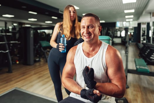 Father and teen daughter training together in a gym, close up