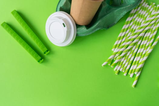 Plastic and recycling concept, closeup top view. Green background with glass, tubes, bag clip, stand, lid