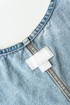 White label on denim clothes with size and brand, place for writing, mockup. Close-up