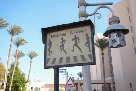 Pedestrian crossing sign with arabic and english letters. High quality photo