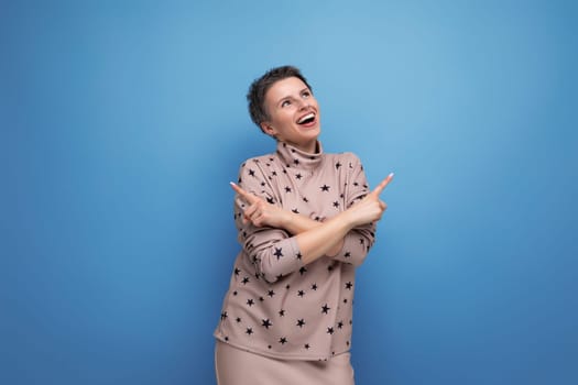 joyful emotional young caucasian dark-haired lady in a skirt and blouse with a short haircut.