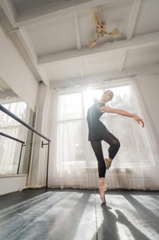 A beautiful Asian woman is dancing at the barre. Ballet dancer