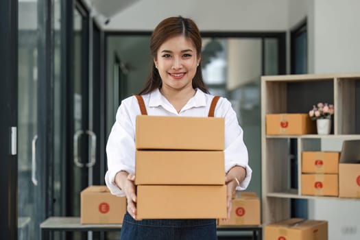 Happy asian woman work from home packaging, on line marketing packaging and delivery, SME concept.