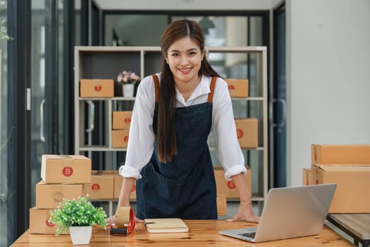 Happy asian woman work from home packaging, on line marketing packaging and delivery, SME concept.