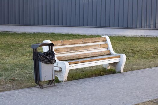 Trash bin and bench in park close up