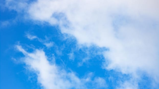 Blue sky with large clouds, blurred background or texture