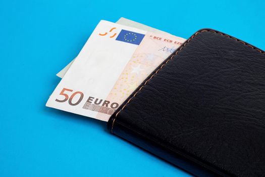 Euro in wallet on a blue background close up