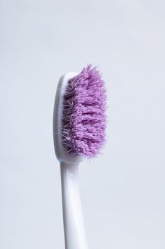 Toothbrush with purple pile close-up on a white background