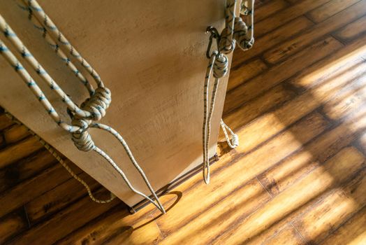 Yoga ropes hanging on studio wall. White background. Iyengar yoga props