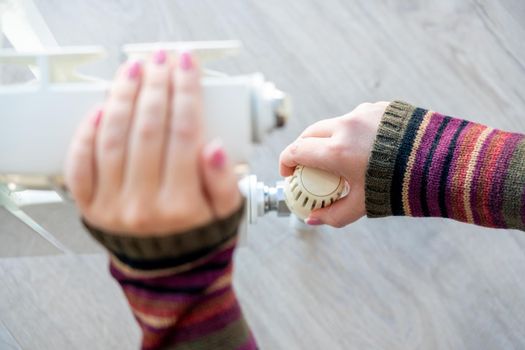 Radiator adjustment closeup, Female hand adjusting radiator temperature