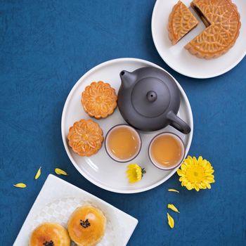 Minimal simplicity layout moon cakes on blue background for Mid-Autumn Festival, creative food design concept, top view, flat lay, copy space.