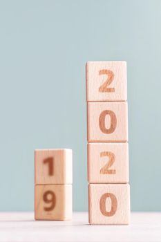 Abstract 2020, 2019 New year target plan design concept - wood blocks cubes on wooden table and pastel green background, close up, blank copy space.