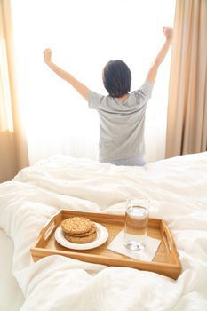 Tray with breakfast on a bed in a hotel room