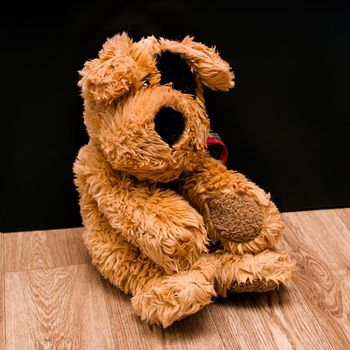 Plush toy dog on wooden floor close up