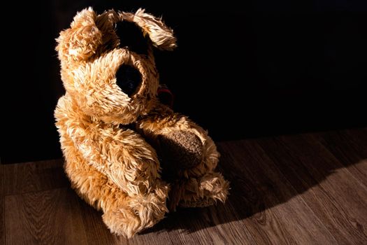 Plush toy dog on wooden floor close up, copy space