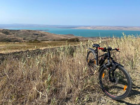 Bike standing on a hill near lake. Panoramic aerial view. Sport and mountain bike concept