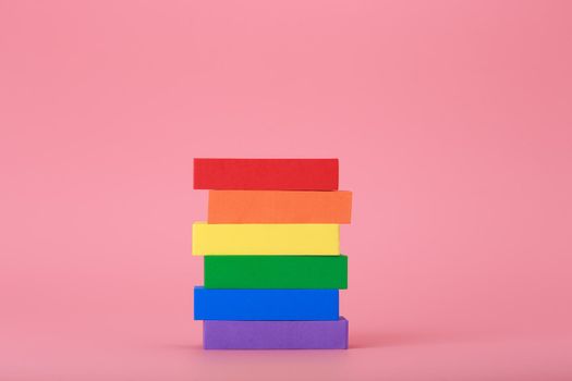 Creative composition with lgbt rainbow flag made of rectangular multicolored tablets on pink background. Concept of Pride Month, equal rights, LGBT community, respect and tolerance.