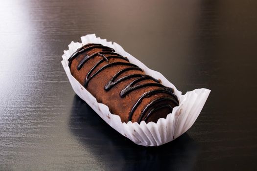 Chocolate cake with cream close up on wooden table