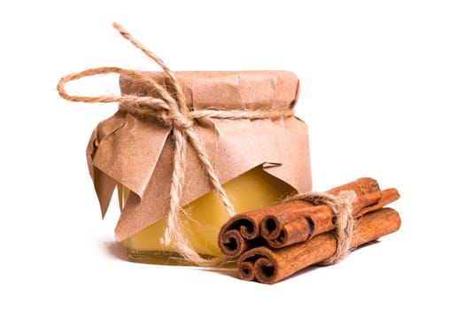 Jar of honey and cinnamon isolated on a white background