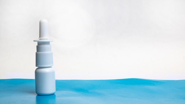 Drops for nose on a blue table, copy space