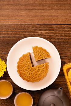 Mid-Autumn Festival holiday concept design of moon cake, mooncakes, tea set on dark wooden table with copy space, top view, flat lay, overhead shot