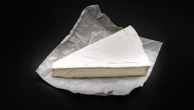 Creame cheese brie on black background. French delicatessen for gourment and healthy nutrition