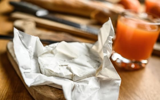 Delicious brie cheese with white mold on a kitchen table