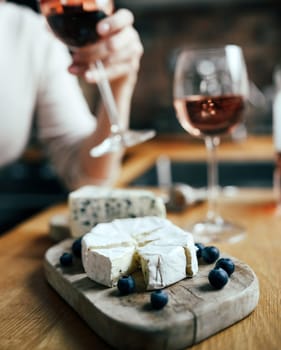 Women drinking a rose wine with french brie cheese plate on a table