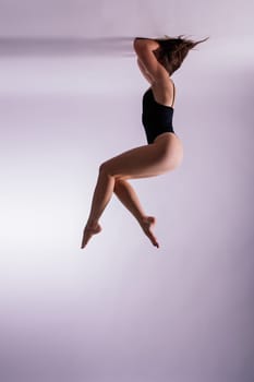 Image of a young plump female doing acrobatic stunt, studio shot