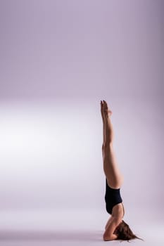 Image of a young plump female doing acrobatic stunt, studio shot