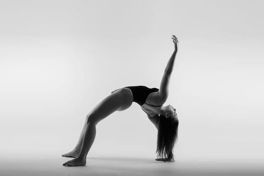 Image of a young plump female doing acrobatic stunt, studio shot