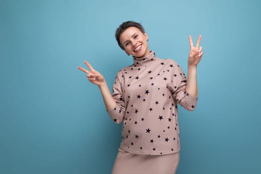 successful 30 year old european business woman with dyed gray hair in a skirt and blouse smiling on a blue background with copy space.