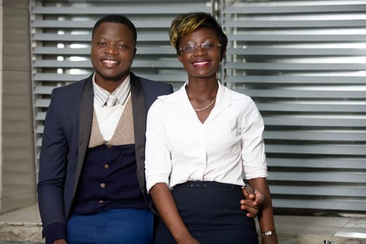 Business people in downtown. Portrait of a business team of a woman and a businessman standing outdoors smiling