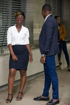 Business people in downtown. Portrait of a business team of a woman and a businessman standing outdoors smiling