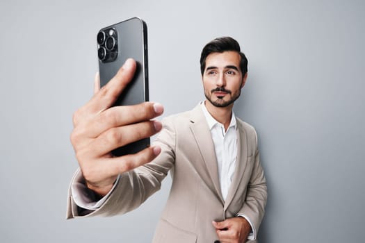 man cyberspace suit smartphone young copy smile confident call business beige space portrait success hold isolated app technology trading phone happy male