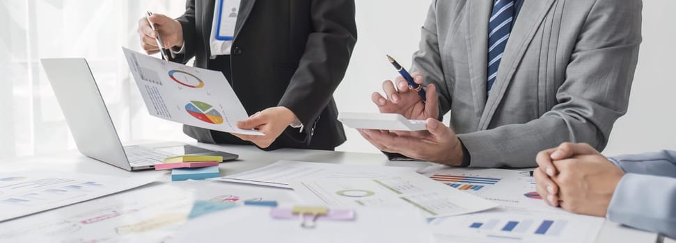 Business People Meeting using laptop computer,calculator,notebook,stock market chart paper for analysis Plans to improve quality next month. Conference Discussion Corporate Concept